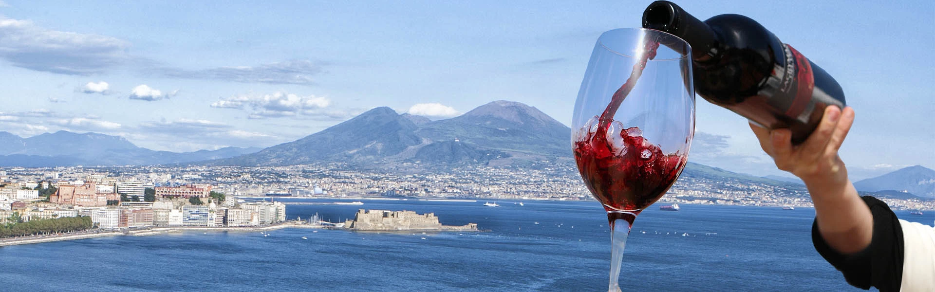 Calice di vino Lacryma Christi in un vigneto sul Vesuvio con il golfo di Napoli sullo sfondo