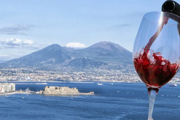 Calice di vino Lacryma Christi in un vigneto sul Vesuvio con il golfo di Napoli sullo sfondo