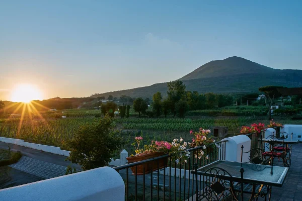 Terrazza panoramica della Cantina del Vesuvio al tramonto, con vista sui vigneti e il cono del Vesuvio sullo sfondo